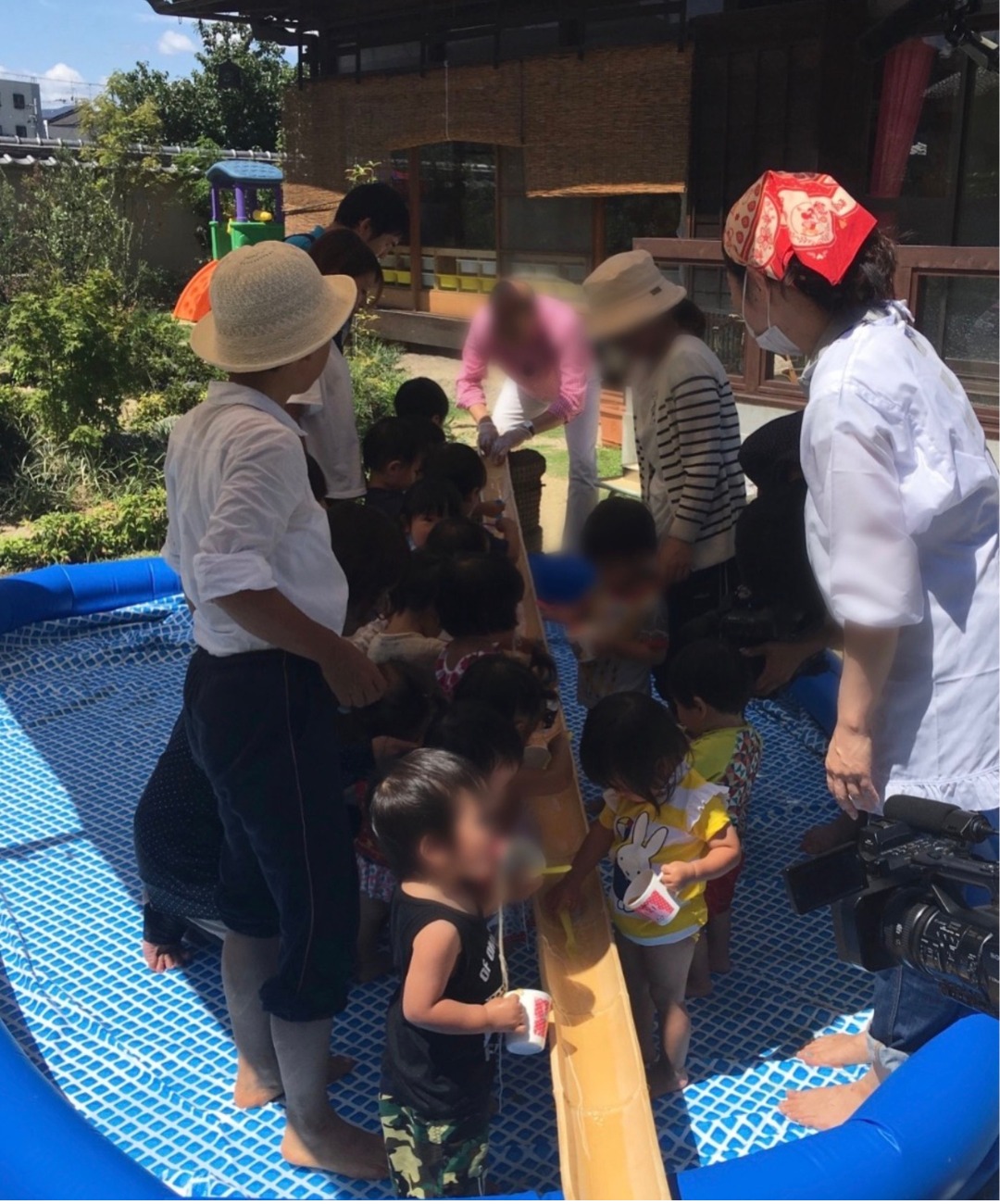 私市保育園にテレビ取材が来た時の様子、一番奥でそうめんを流す人が本人